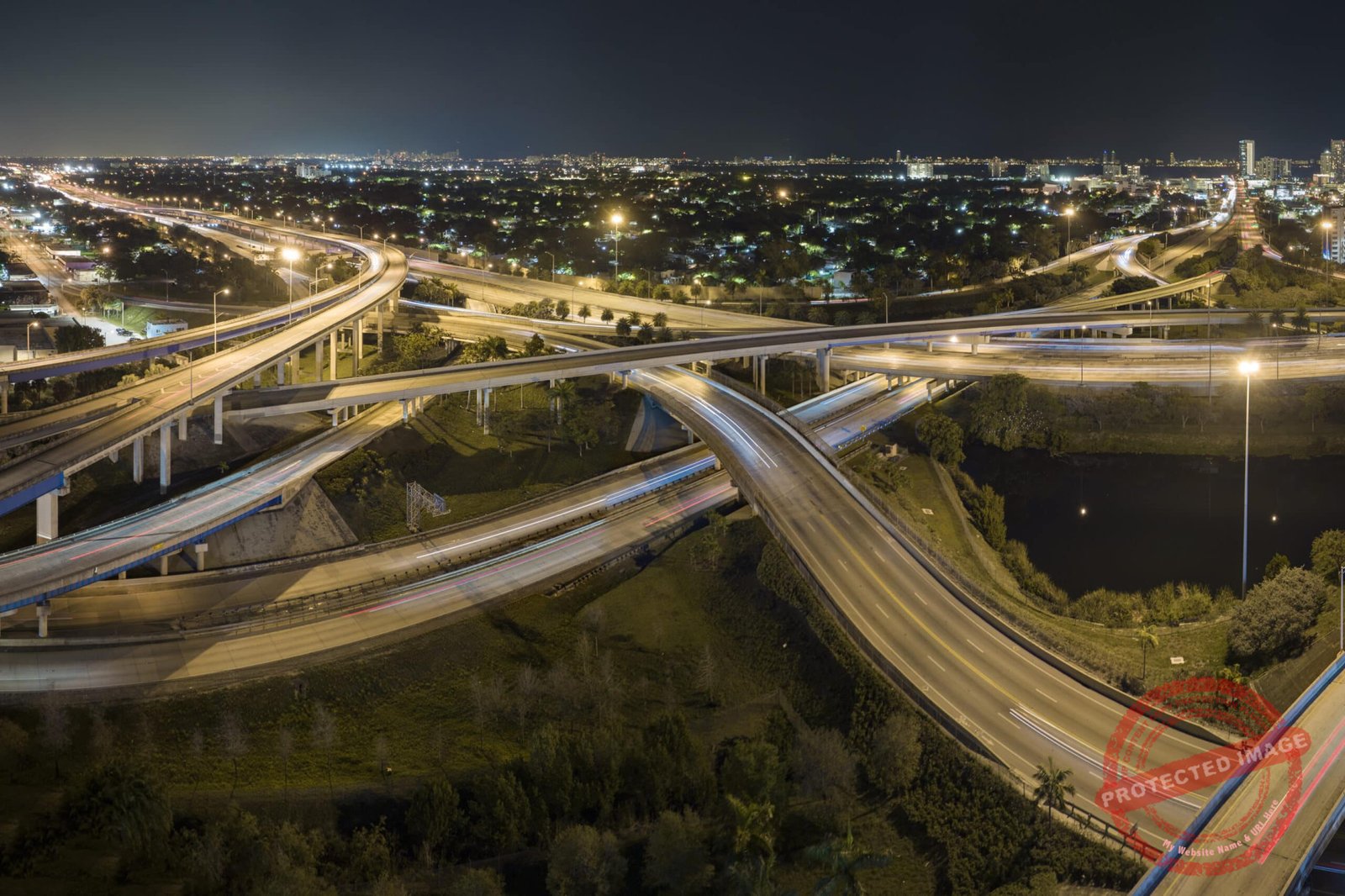 Aerial view of american freeway intersection at night with fast driving cars and trucks in Miami, Florida. View from above of USA transportation infrastructure.