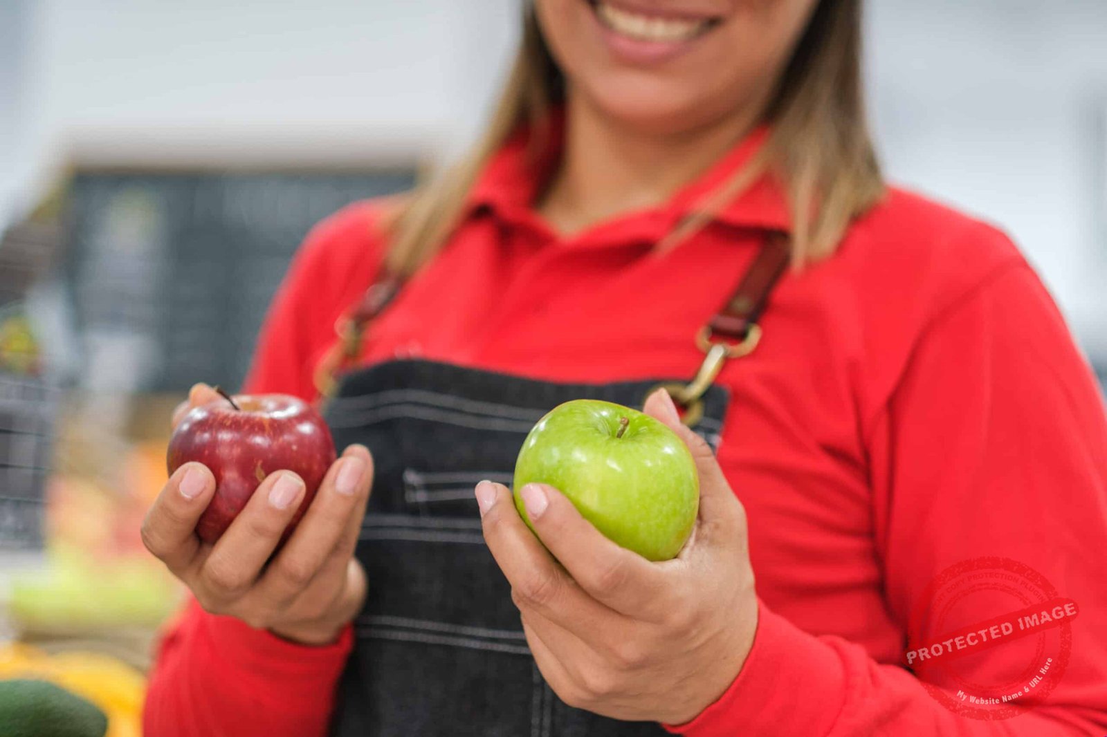 Woman holding two apples, with focus on the fruit
