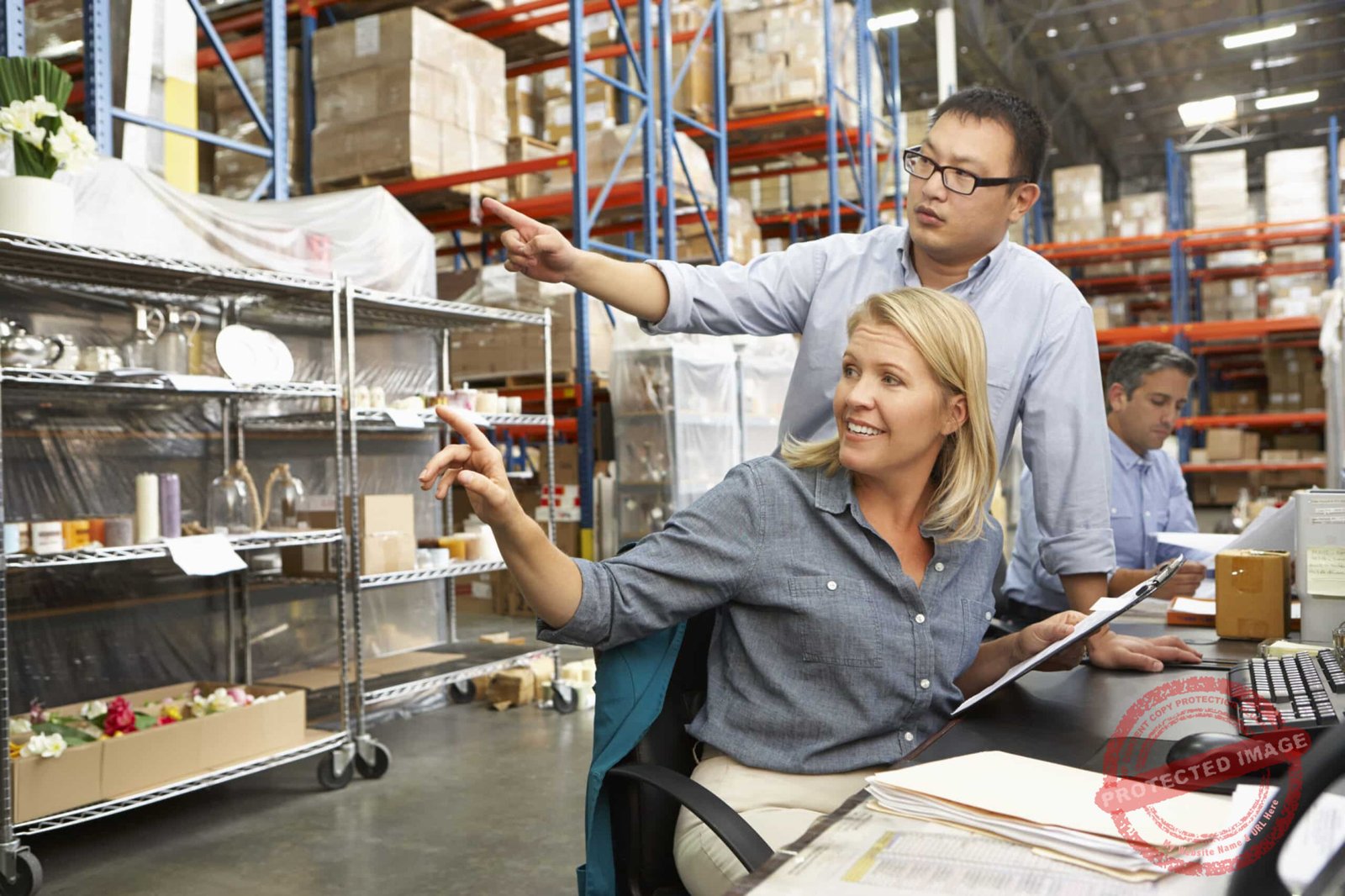 Business Colleagues Working At Desk In Warehouse